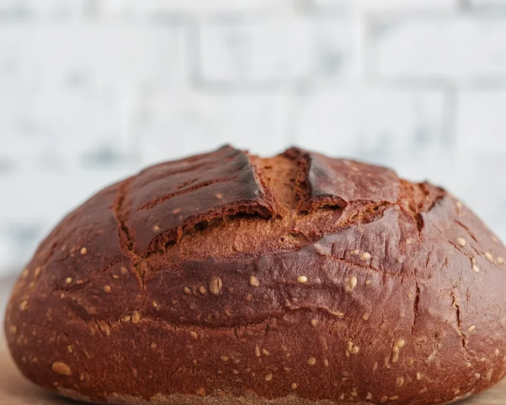 Gluten free artisan rye bread fresh out of the oven, showcasing a perfect crust and fluffy interior.