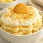 Gluten-free banana pudding dessert served in a bowl with whipped cream.