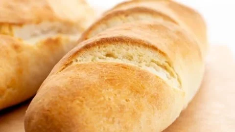 Gluten free French bread baguettes baked to perfection on a wooden board