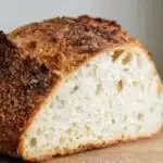 Freshly baked no knead gluten free bread loaf on a wooden board